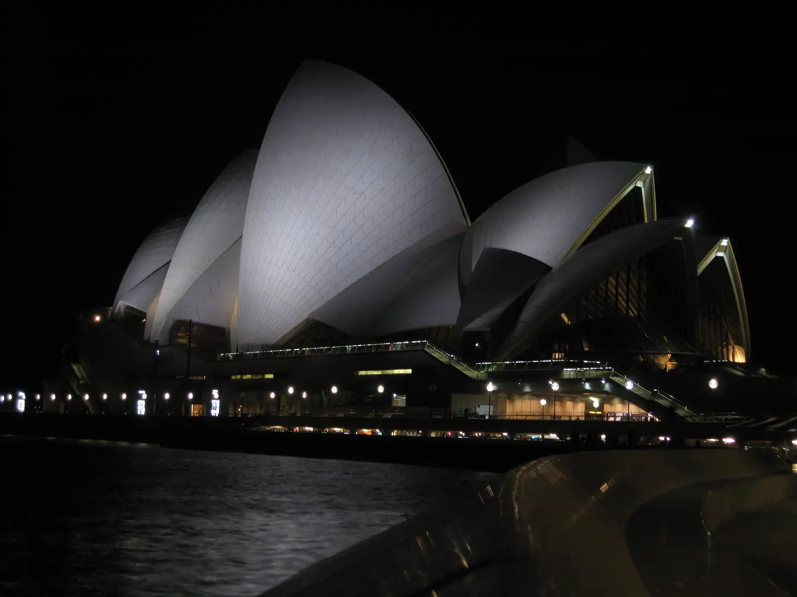Sydney Opera House lit up at night over the harbour